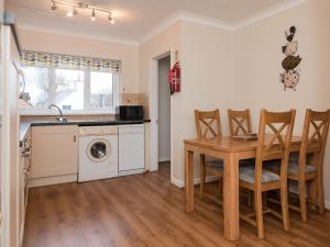 a kitchen and dining room with a table and a washing machine at Dolphin Cottage - Uk6733 in Lydstep