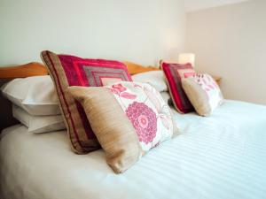 two pillows sitting on top of a bed at Dolphin Cottage - Uk6733 in Lydstep