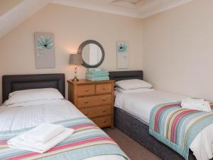a bedroom with two beds and a mirror at Dolphin Cottage - Uk6733 in Lydstep +8 photos