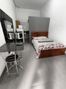 a bedroom with a bed and a desk and a table at Lar Doce Lar Realizando Sono!!! in Arcos