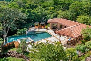 an aerial view of a house with a swimming pool at Treetop Ocean View Penthouse - Jobo 15 in Playa Conchal +61 photos