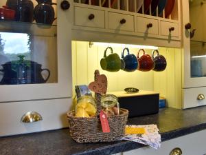 eine Küchentheke mit einem Korb mit Lebensmitteln und Küchenutensilien in der Unterkunft Garden Cottage in Sabden + 11 Fotos