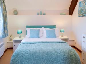 a bedroom with a blue bed with two night stands at Discovery in Cheriton Bishop
