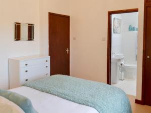 a bedroom with a bed and a bathroom with a sink at Discovery in Cheriton Bishop +10 photos