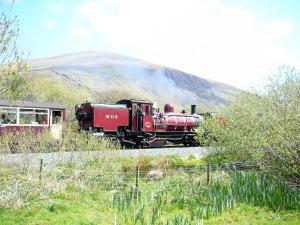 Er rijdt een rode trein over de rails. bij Seion - Hw7575 in Llanddeiniolen +1 foto