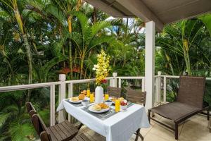 a white table with food on a porch with chairs at Serene Maui Retreat Walk to Beach & Shops in Wailea