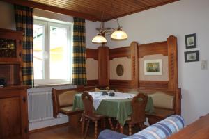 ein Esszimmer mit einem Tisch, Stühlen und einem Fenster in der Unterkunft Ferienwohnung Winklhofer in Mondsee
