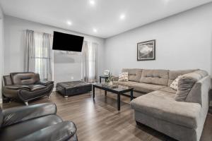 a living room with a couch and a tv at Modern 5BR Home Perfect for Families in Niagara Falls
