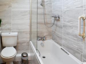 een badkamer met toilet en ligbad bij The Milking Parlour - 18436 in Bempton