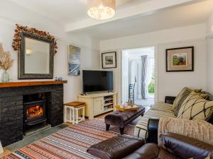 a living room with a couch and a fireplace at Yew Tree House in Chideock