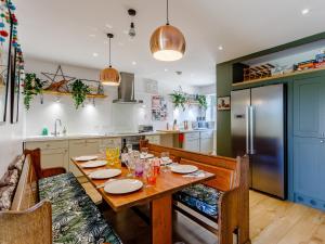 a kitchen with a wooden table and a refrigerator at Yew Tree House in Chideock
