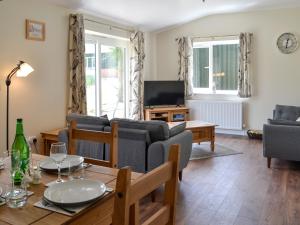 a living room with a couch and a table at Deer Cottage 2 Uk39332 in Biddenden +14 photos