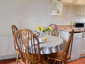 a kitchen with a table and chairs with flowers on it at Celtic Retreat - Uk6721 in Lydstep