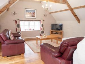 a living room with leather furniture and a tv at Celtic Retreat - Uk6721 in Lydstep +7 photos