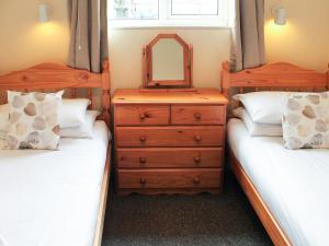 een slaapkamer met 2 bedden en een dressoir met een spiegel bij Tom Putt in Ledbury +1 foto