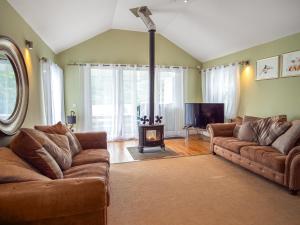 a living room with two couches and a fireplace at Chapelburn in Lawers