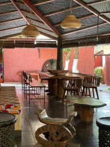 eine Bar mit Holztischen und -stühlen in einem Restaurant in der Unterkunft La Tour Rouge in M'bour