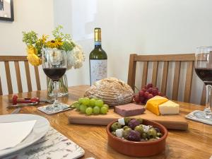 a table with a bunch of cheese and wine at Lavender Cottage in Shrewsbury