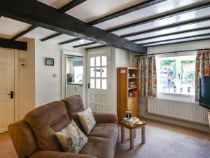 a living room with a couch and a tv at Lavender Cottage in Shrewsbury