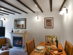 a dining room with a table and a fireplace at Lavender Cottage in Shrewsbury