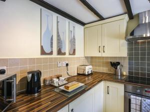 a kitchen with white cabinets and a counter top at Lavender Cottage in Shrewsbury +13 photos