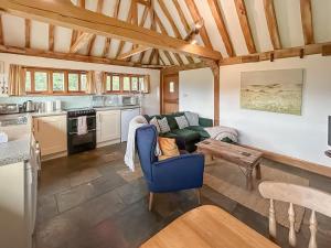 eine Küche und ein Wohnzimmer mit einer Couch und einem Tisch in der Unterkunft Heron Barn in Hollingbourne