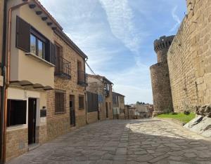 a cobblestone street in a village with buildings at Castillo 22 in Oropesa