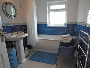 a bathroom with a tub and a sink and a mirror at Ty Clyd - Hw7657 in Walton East