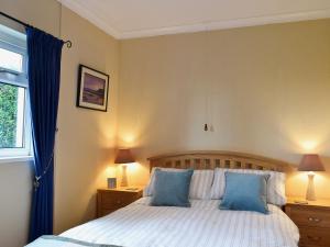 a bedroom with a bed with two blue pillows at Ty Clyd - Hw7657 in Walton East
