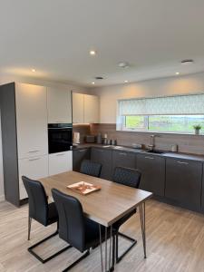 a kitchen with a wooden table and black chairs at Stylish Cosy Stunning View Villa in Kirkwall, Free Parking and WiFi in Orkney