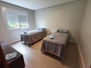 a room with two beds and a window at Casa em Dois Irmãos in Dois Irmãos