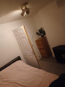 a bedroom with a bed and a white door at Cozy King Room with Shared Kitchen & Bathroom in Lewisham