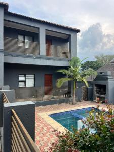 a house with a swimming pool in front of it at Nelspruit Madiva Guest House in Nelspruit