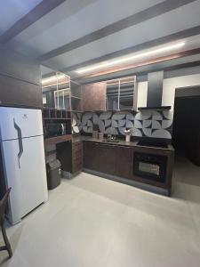 Apartamento Charmoso com Mezanino em Juquehy في ساو سيباستياو: مطبخ مع ثلاجة بيضاء ومغسلة