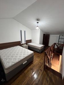 Apartamento Charmoso com Mezanino em Juquehy في ساو سيباستياو: غرفه سريرين ودرج فيها