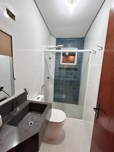 Apartamento Charmoso com Mezanino em Juquehy في ساو سيباستياو: حمام مع حوض ومرحاض ونافذة +3 صور