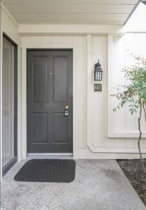 a black door on a white house with a lamp at Romantic Napa Escape Prime Location in Vichy Springs