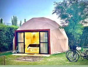 a tent with a bike parked in the grass at Glamping en zona de Bodegas Luján de Cuyo Mendoza in La Porteña
