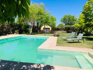 einen Pool im Garten mit zwei Stühlen und einem Tisch in der Unterkunft Glamping en zona de Bodegas Luján de Cuyo Mendoza in La Porteña