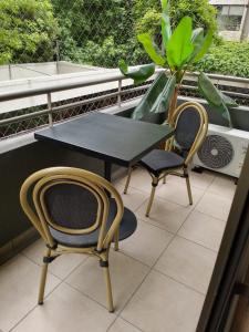 Una mesa y dos sillas en un balcón. en Exclusivo depto con AC y piscina Ñuñoa, en Santiago
