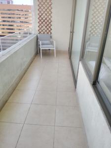 balcón con silla y ventana en Exclusivo depto con AC y piscina Ñuñoa, en Santiago
