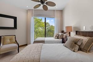 a bedroom with two beds and a ceiling fan at Treetop Ocean View Penthouse - Jobo 15 in Playa Conchal