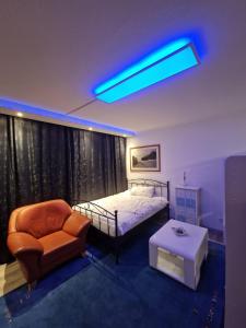 a bedroom with a bed and a chair and a table at quiet apartment 2 in Rüsselsheim