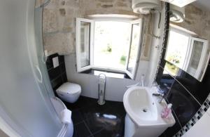 Un baño con lavabo, inodoro y espejo. en Palace Inn Rooms, en Split 29 fotos más