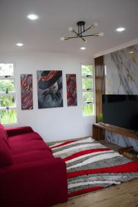 een woonkamer met een rode bank en een flatscreen-tv bij Villa Pool Path to Tortuguero in Barrio Palermo