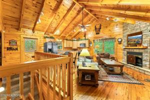 a log cabin living room with a wooden ceiling at Along the Trail Cabin with Hot Tub Pool Pond Game Room in Wear Valley