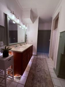 a bathroom with a sink and a large mirror at Peaceful Guest Suite with Microwave & Fridge in Lafayette