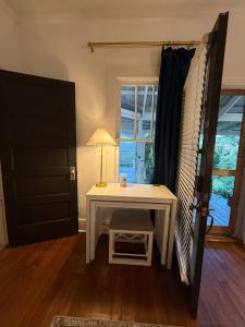 a white table with a lamp next to a window at Peaceful Guest Suite with Microwave & Fridge in Lafayette