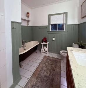 a green bathroom with a tub and a toilet at Peaceful Guest Suite with Microwave & Fridge in Lafayette