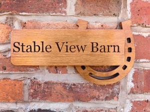 a sign that reads stable view barn hanging on a brick wall at Stable View Barn - Uk45938 in Corley